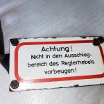 Schild: „Achtung! Nicht in den Ausschlagbereich des Reglerhebels vorbeugen!“
